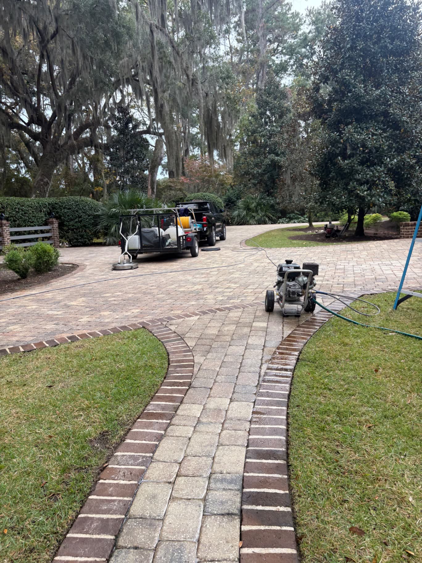 ALC Cleaning truck and pressure washing equipment on a paver driveway