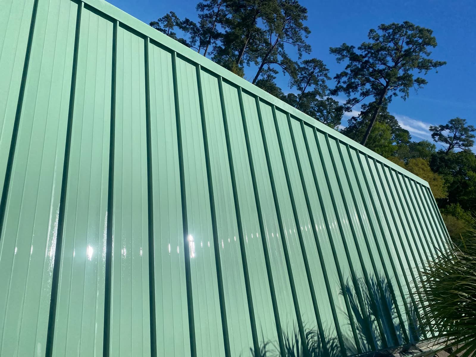 The same metal fence panels rinsed clean and glossy after cleaning
