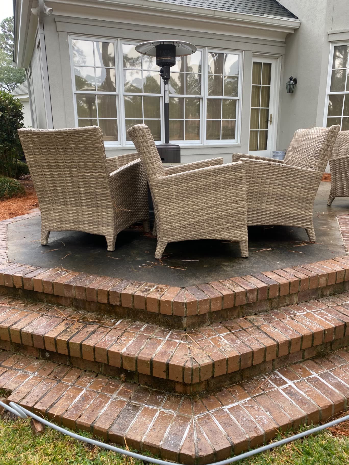Brick steps and concrete patio with outdoor furniture