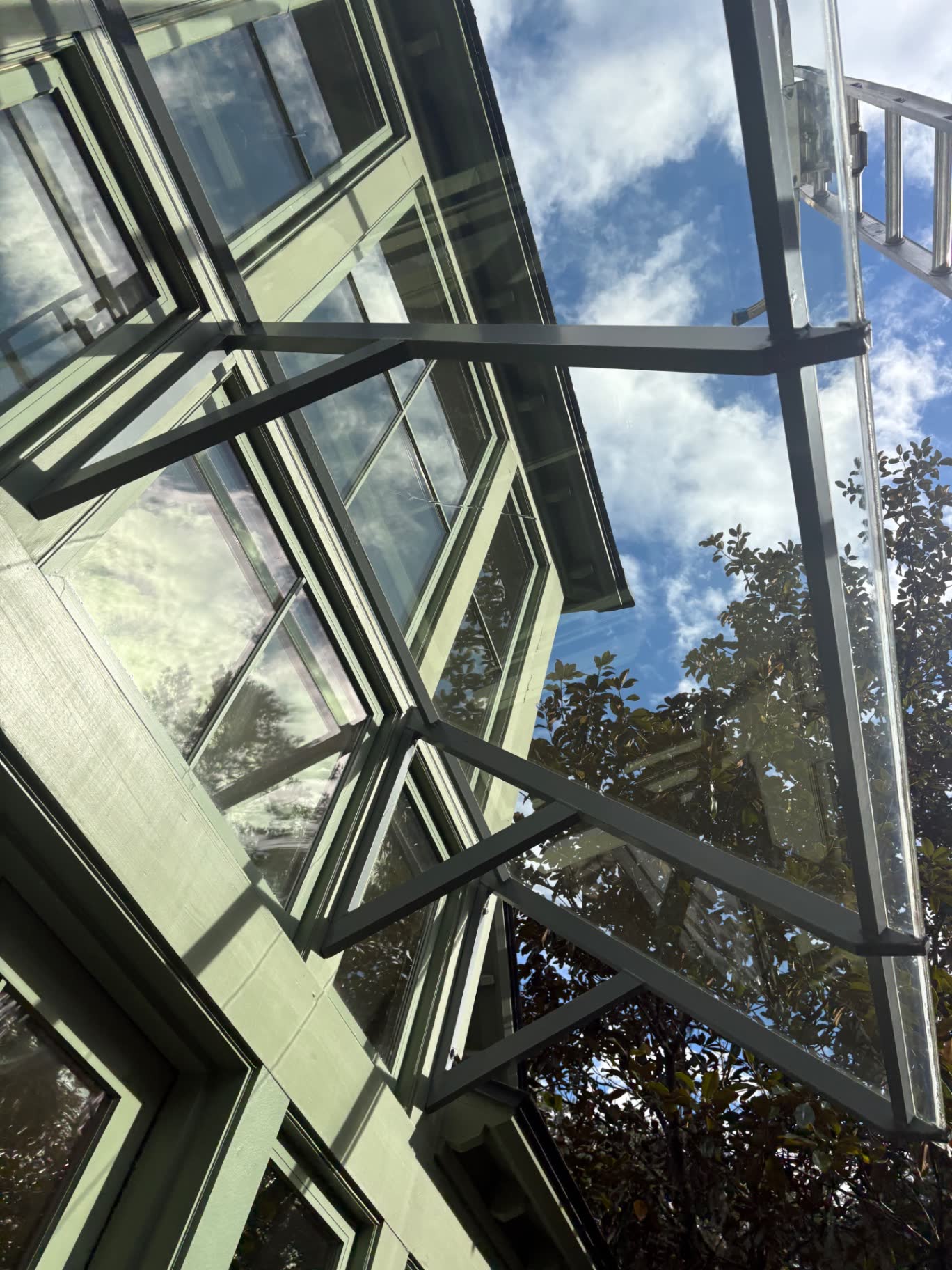 Clean exterior windows and glass panels reflecting a blue sky