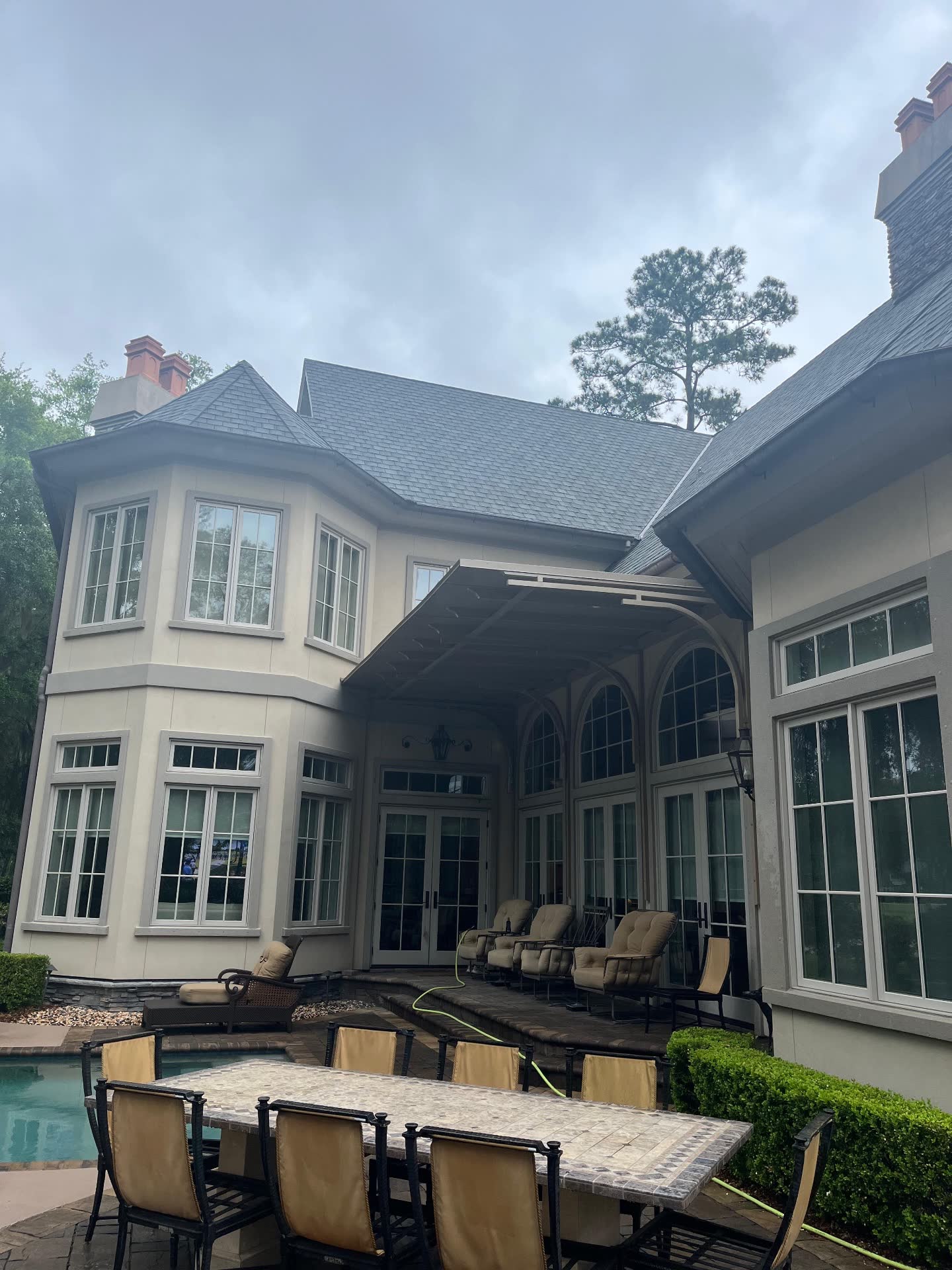 Large home exterior and pool patio after exterior cleaning